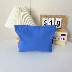 Détail d'une trousse de toilette en nylon bleu roi avec fermeture éclair et étiquette