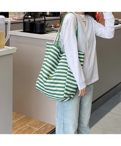 Détail du sac cabas en toile rayé vert et blanc avec plaque en métal faite à la main