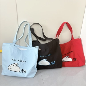 Detail showing high-capacity canvas tote bags with rabbit embroidery and drawstring closure
