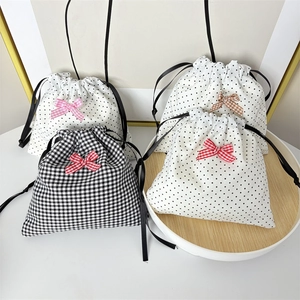 Detailed close-up of polka dot and houndstooth drawstring pouches with cute ribbon bows