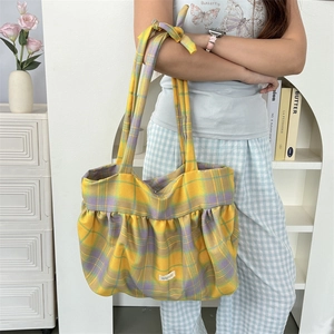 Détail du sac cabas en toile à carreaux jaunes avec plis froncés et bride à nœud