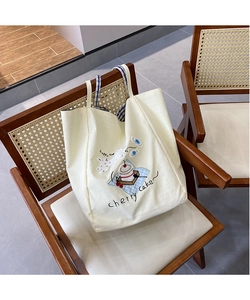 Detailed embroidery on cream canvas tote bag featuring cute cartoon bears and cakes