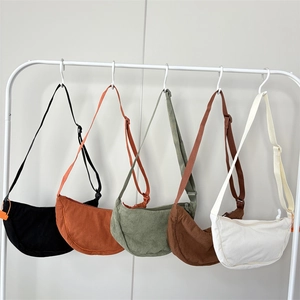 Large corduroy crossbody crescent bags shown in five colors with adjustable straps