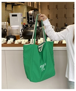 Détail d'un grand sac cabas en toile verte avec lettrage blanc en décor de style de vie