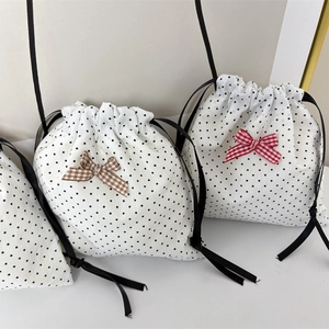 Close-up of polka dot drawstring bags with plaid bows and elegant satin ribbons