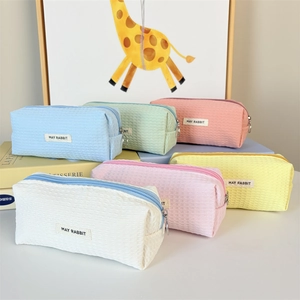 Close-up of colorful waffle texture pencil cases with brand labels and metal zippers