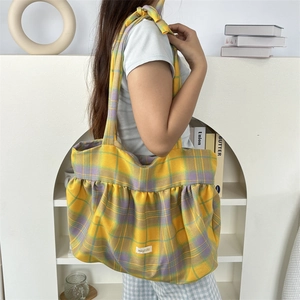 Gros plan sur un sac cabas à carreaux avec volants et motif écossais jaune-violet