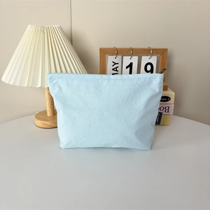 Gros plan de la trousse de maquillage en nylon bleu clair avec fermeture éclair noire