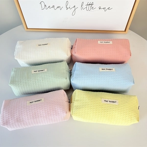 Flat lay of macaron-colored waffle fabric pencil cases in six different pastel shades