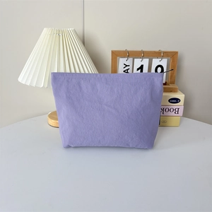 Détail de la trousse cosmétique en nylon lilas clair avec texture imperméable fine