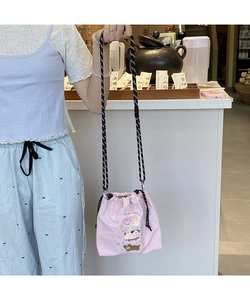 Detail of pink canvas drawstring bucket bag featuring a colorful cartoon animal illustration
