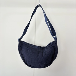 Detail of navy blue corduroy fabric texture and crescent moon crossbody bag zipper