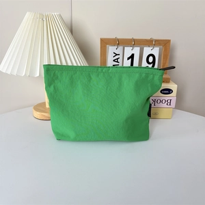 Gros plan d'une trousse de maquillage en nylon vert imperméable avec fermeture éclair
