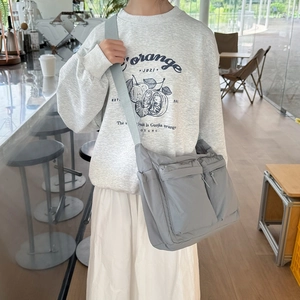 Détail du sac bandoulière en nylon gris clair avec deux poches zippées fonctionnelles
