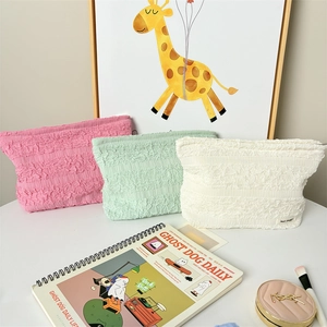 Three textured bubble cosmetic bags in pink, green, and white colors in a lifestyle setting