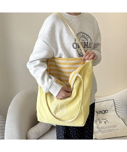 Détail du sac fourre-tout en toile jaune avec illustration de chien et doublure rayée