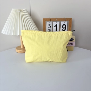 Détail du tissu en nylon imperméable jaune pâle et de la fermeture éclair noire