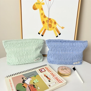 Close-up of pleated texture makeup bags in light green and blue with May Rabbit label