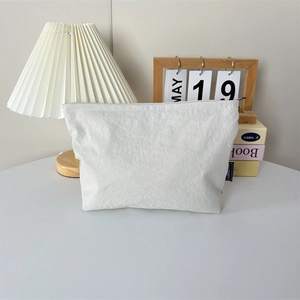 Détail de la trousse de toilette blanche en nylon imperméable avec zip et étiquette latérale