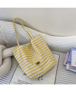 Détail du sac cabas en toile à rayures jaunes et blanches avec étiquette rétro