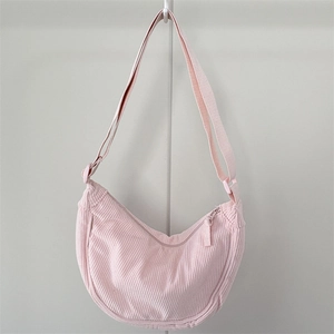 Detail view of pink corduroy moon bag with vertical texture and adjustable strap