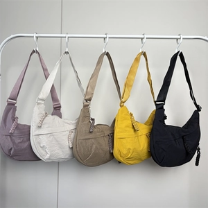 Five colors of nylon dumpling bags hanging on a rack showing various versatile color options