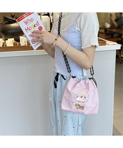 Detail of pink canvas drawstring bucket bag featuring colorful animal party embroidery
