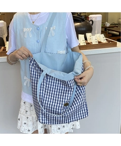 Close-up of the spacious interior and blue-white checkered fabric of the canvas tote bag