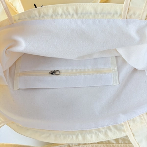 Detail of canvas tote interior with heart zipper pull and inner zip pocket