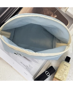 Vista dall'alto della spaziosa borsa da toilette in nylon celeste con zip e trucchi