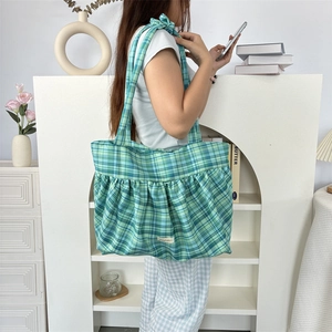 Détail du grand sac cabas à carreaux bleu et vert avec design froncé et étiquette