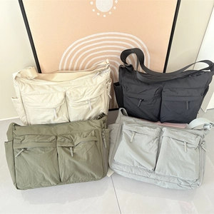 Détail de grands sacs à bandoulière en nylon disponibles en beige noir vert et gris