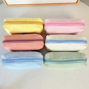 Flat lay of six waffle weave organizer pouches in assorted macaron pastel colors