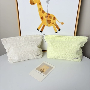 Detailed view of bubble texture on white and yellow makeup bags with logo labels