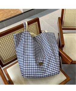 Detailed view of handmade oval label on blue and white plaid canvas tote bag