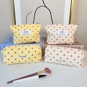 Floral makeup pouch set in cream and yellow featuring textured puff fabric and 4 pieces