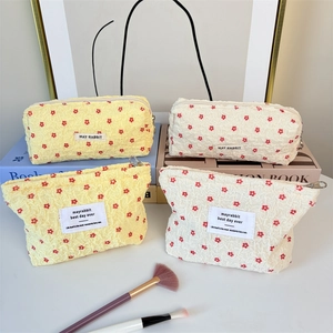 Floral seersucker cosmetic bag set featuring four yellow and cream quilted storage pouches