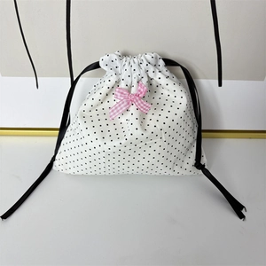 Detail of polka dot jewelry pouch with pink gingham bow and black satin drawstring