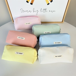 Six multi-colored waffle fabric pencil cases in pastel tones with zipper closures