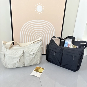 Détail de sacs bandoulière en nylon beige et noir avec deux poches et style technique