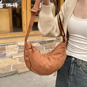 Detail of brown corduroy crossbody bag with adjustable strap and textured fabric finish