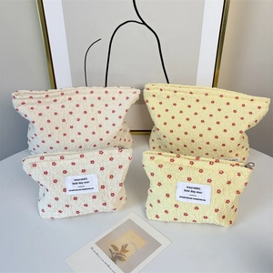 Detail of floral seersucker cosmetic bags with red flower pattern and metal zipper