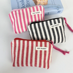 Detail view of colorful striped canvas coin purses with zippers and woven lanyards
