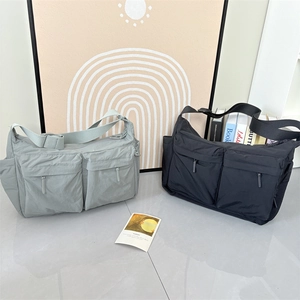 Détail de sacs bandoulière en nylon gris et noir avec doubles poches et sangles