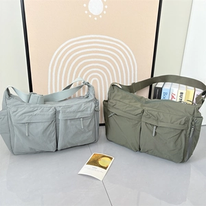 Détail de sacs bandoulière en nylon bleu clair et vert olive avec plusieurs poches cargo