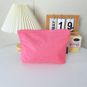 Détail de la trousse de maquillage rose en nylon imperméable avec fermeture éclair