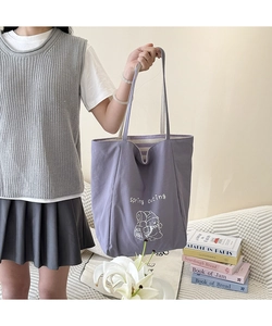 Gros plan d'un sac fourre-tout en toile violette avec texte et illustration de dessin animé