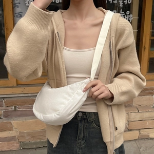 Detail view of white corduroy crescent crossbody bag styled on a female model