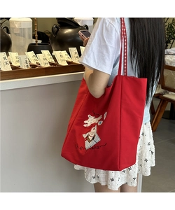 Detail of red canvas tote bag with white cartoon animal and Cherry Cake embroidery
