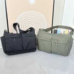 Détail de sacs bandoulière en nylon noir et vert olive avec design fonctionnel multi-poches